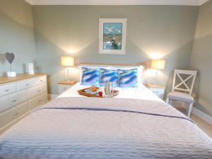ein Schlafzimmer mit einem Bett und einem Tablett mit Büchern darauf in der Unterkunft Crabbe Corner in Aldeburgh