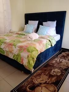 a bedroom with a bed with a rug on the floor at Lovely Pearl Intercity Homes in Dar es Salaam