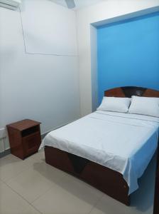 1 dormitorio con cama y mesita de noche en Emmanuel&Cavita, en Iquitos