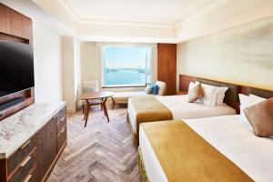 um quarto de hotel com duas camas e uma televisão de ecrã plano em InterContinental Tokyo Bay, an IHG Hotel em Tóquio