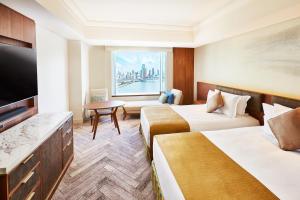 a hotel room with two beds and a flat screen tv at InterContinental Tokyo Bay by IHG in Tokyo