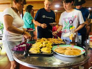 a group of people standing around a table with food at Duong Cong Chich Homestay in Lạng Sơn