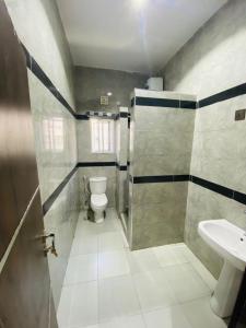 a bathroom with a toilet and a shower and a sink at Officer Condo Apartments in Yanyan