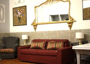 Appartamento blu centro storico في بولونيا: غرفة معيشة مع أريكة حمراء ومرآة