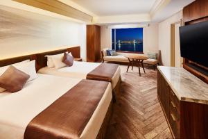 a hotel room with two beds and a flat screen tv at InterContinental Tokyo Bay by IHG in Tokyo