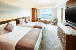 a hotel room with two beds and a flat screen tv at InterContinental Tokyo Bay by IHG in Tokyo