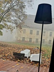 two chairs and a lamp in front of a building at Domki Hrabiego- domek nr 2 in Rozkochów