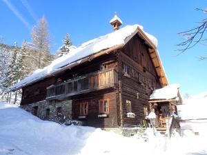 una cabina in legno con neve sul tetto di Holiday home Mesnerhaus Fuchsn, Weisspriach im Lungau a Weisspriach