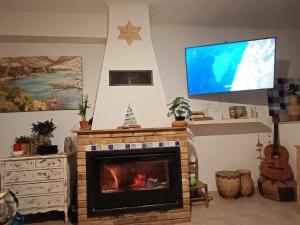 sala de estar con chimenea y TV de pantalla plana en Flaire Mar, en Tarragona
