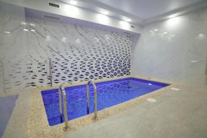 a swimming pool in a bathroom with a tile wall at Milan Hotel in Tashkent