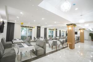 a dining room with couches and tables and chairs at Milan Hotel in Tashkent