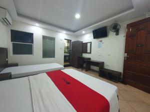 a bedroom with a bed with a red and white blanket at Ha Noi Vang Hotel Hoang Ngan in Hanoi