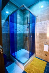 a shower with a glass door in a bathroom at Bays Lodge - East Legon in Accra