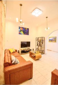 a living room with a couch and a television at Bays Lodge - East Legon in Accra