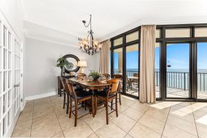 a dining room with a table and chairs and a balcony at The Oasis at Orange Beach 2203 in Orange Beach