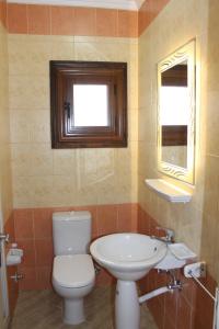 a bathroom with a toilet and a sink and a window at Herrmes Hostel in Sharm El Sheikh