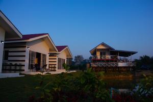 a house with a balcony in front of it at บ้านสวนมะม่วงรีสอร์ท in Ban Klang