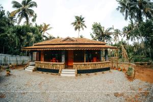 Munroe IslandMundro Garden Homestay的棕榈树前的小房子