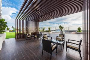 a patio with tables and chairs and a view at Amber Cove Premier Suites Melaka in Melaka