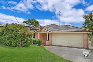 a red brick house with a white garage at KozyGuru / Penrith / Cosy 4BED House / Free Internet NPE051 in Penrith