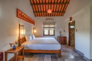 1 dormitorio con 1 cama grande y techo de madera en Gita Boutique Villa, en Hoi An