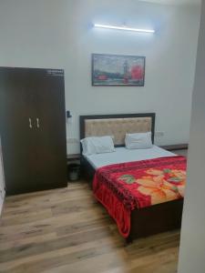 um quarto com uma cama com um cobertor vermelho em hotel khubsaras palace by chhabra's em Agra