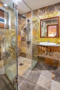 ein Bad mit einer Dusche und einem Waschbecken in der Unterkunft Gita Boutique Villa in Hoi An