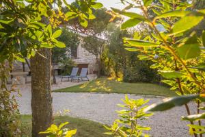 um jardim com uma mesa e uma cadeira em frente a um edifício em Villa Ginepro (Country House) em Dorgali