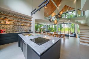 an open kitchen and dining room with a large island at Villa Satiya - Unique and stylish 4-bdr pool villa in Pererenan! in Canggu