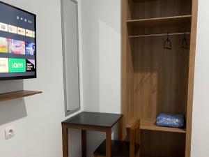 um quarto com uma porta, uma mesa e uma televisão em RedDoorz Plus near Alun Alun Kota Bora em Blora