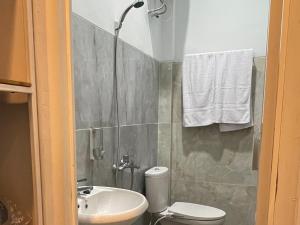 uma casa de banho com um chuveiro, um WC e um lavatório. em RedDoorz Plus near Alun Alun Kota Bora em Blora