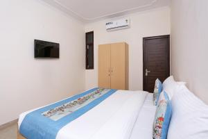 a white bedroom with a large bed in it at OYO Dlf Cyber City Near Aravali Biodiversity Park in Gurgaon