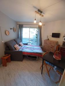 sala de estar con sofá y cama en Appartement en résidence. Barèges, en Barèges