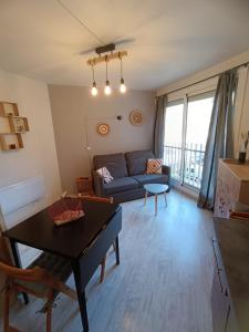 sala de estar con sofá y mesa en Appartement en résidence. Barèges, en Barèges