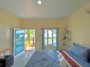 Ban Pak Ba RaにあるAva Beach Pakbaraのベッドルーム1室(ベッド1台付)、スライド式ガラスドアが備わります。