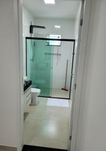a bathroom with a glass shower and a toilet at Kit Dona Branca in Alto Paraíso de Goiás