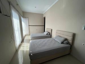 1 Schlafzimmer mit 2 Betten und einem Fenster in der Unterkunft Guest House DiFi Timoho in Demangan
