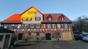 una casa grande con techo amarillo y rojo en Ramsbacher Ferienwohnung, en Schwäbisch Hall