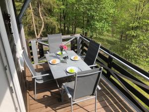 una mesa y sillas en un balcón con vistas en Fewo Nartura: Modern – Idyllisch – stilvoll – ruhig, en Sankt Andreasberg