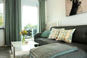 ein Wohnzimmer mit einem Sofa und einem Tisch in der Unterkunft Fewo Nartura: Modern – Idyllisch – stilvoll – ruhig in Sankt Andreasberg