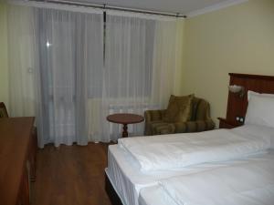 a hotel room with a bed and a chair at Park Hotel Izvorite in Kotel