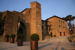 a brick building with potted plants in front of it at La CoCCa Luxury Villa in Monticchiello, your heaven in Tuscany in Monticchiello