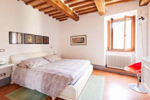 a white bedroom with a bed and a window at La CoCCa Luxury Villa in Monticchiello, your heaven in Tuscany in Monticchiello