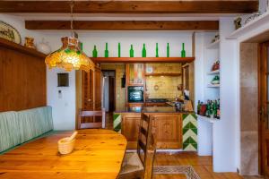uma cozinha com uma mesa de madeira e garrafas verdes na parede em El Olivo em Inca