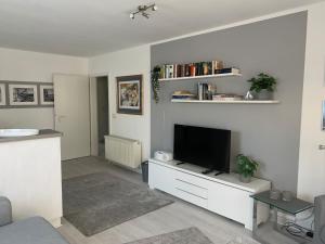 a living room with a tv on a white wall at Strandkieker 13, PP innen in Zingst