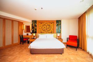 um quarto com uma cama e 2 cadeiras vermelhas em Centara Nova Hotel Pattaya em Pattaya Central
