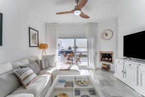 a living room with a white couch and a fireplace at 228 Arruzafa Playa La cala de Mijas in La Cala de Mijas