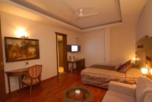 a hotel room with a bed and a table at Vikram Vintage Inn in Nainital