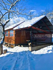 a cabin with a snow covered roof in the snow at Під лісом у гіда in Yaremche