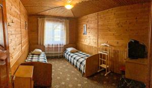 a room with two beds and a tv in it at Під лісом у гіда in Yaremche